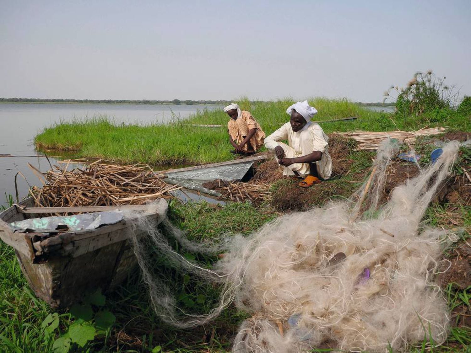 Dois pescadores trabalham em uma ilhota do lago Chad. Em meio sÃ©culo, as secas reduziram em mais de 90% esta grande massa de Ã¡gua.