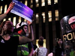 Mulher exibe placa em homenagem a Marielle Franco nesta quinta-feira em São Paulo.