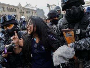 A polícia boliviana detém uma manifestante em La Paz em 21 de novembro.